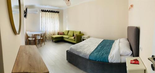 een slaapkamer met een bed, een bank en een tafel bij N&N Apartment in Përmet