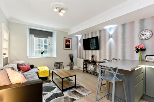 a living room with a couch and a table at Ultra Modern, West End Village, Refurbished basement appt in Edinburgh