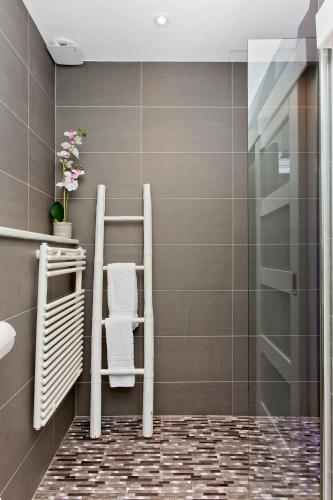 a bathroom with two towel racks and a shower at Ultra Modern, West End Village, Refurbished basement appt in Edinburgh