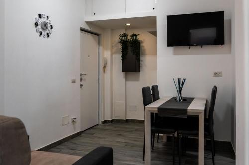 a dining room with a table and a television on the wall at L’Archè Lodovico il Moro – House on the Navigli River in Milan