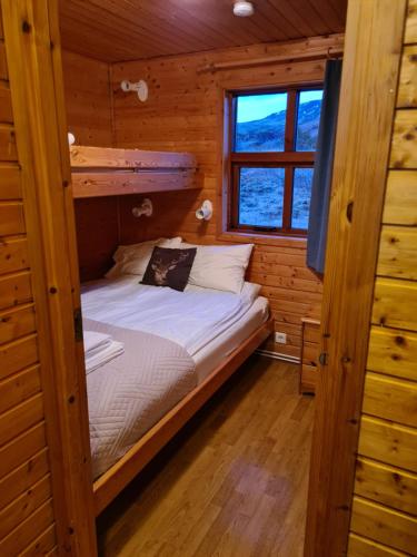 1 dormitorio con 1 cama en una cabaña de madera en Gljúfurbústaðir Holiday Homes, en Hveragerði