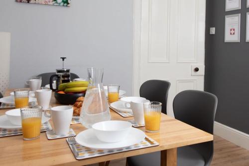a wooden table with plates and glasses of orange juice at The Old Post House in Kyle of Lochalsh