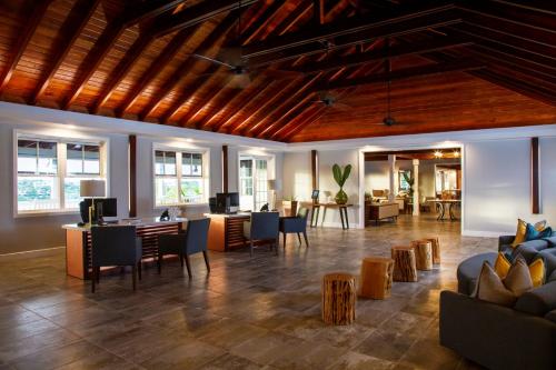 a large room with a lobby with tables and chairs at Hammock Cove Antigua - All Inclusive - Adults Only in Willikies