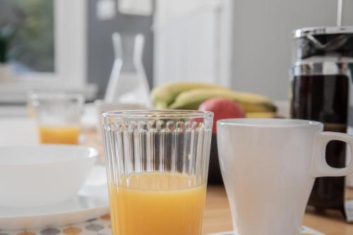a glass of orange juice next to a cup of orange juice at The Old Post House in Kyle of Lochalsh