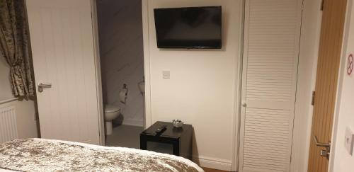 a bedroom with a bed and a television on the wall at Bell Inn in Evesham