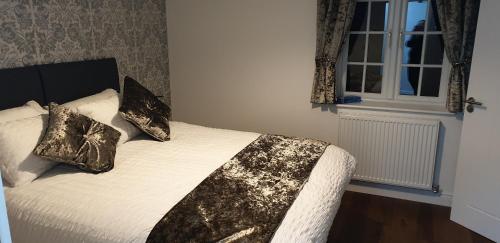 a bedroom with a bed with pillows and a window at Bell Inn in Evesham