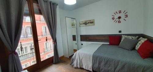 um quarto com uma cama e um relógio na parede em Apartamento centro Málaga em Málaga