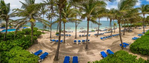 an aerial view of a beach with chairs and palm trees at St. James's Club Resort - All Inclusive in English Harbour Town