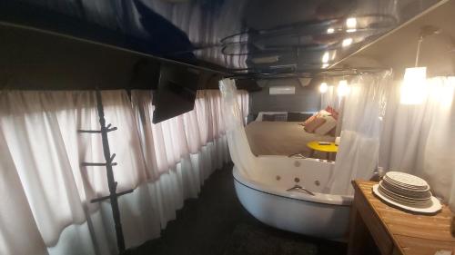 a small bathroom with a tub and curtains at LolosaBUS - Não é apenas uma hospedagem e sim uma EXPERIÊNCIA! in Ubatuba