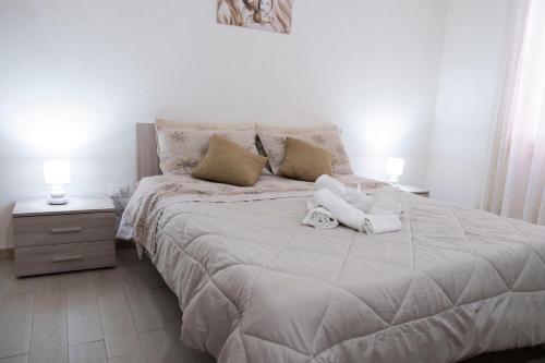 a white bed with two pillows on it in a bedroom at A due passi dal centro e dal mare in Marsala