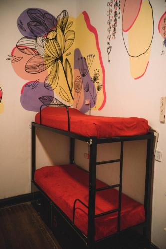 a bunk bed with a flower mural on the wall at IDEAL SOCIAL Hostel in Buenos Aires