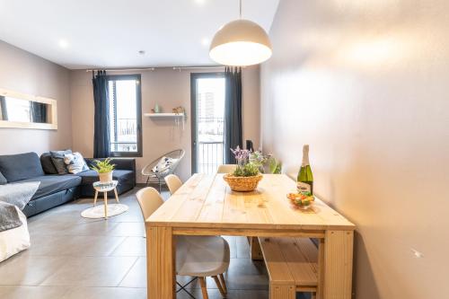 a dining room and living room with a wooden table at Bo&Co Apartments in Sitges