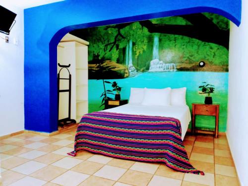 a bedroom with a bed with a painting on the wall at HOTEL ESMERALDA in Tampico