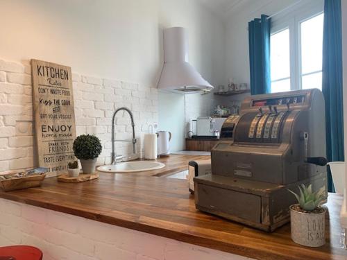 - une cuisine avec un comptoir et une machine dans l'établissement L'ALBERT 1er - Ancien Palace - Centre ville - Terrasse, à Vichy