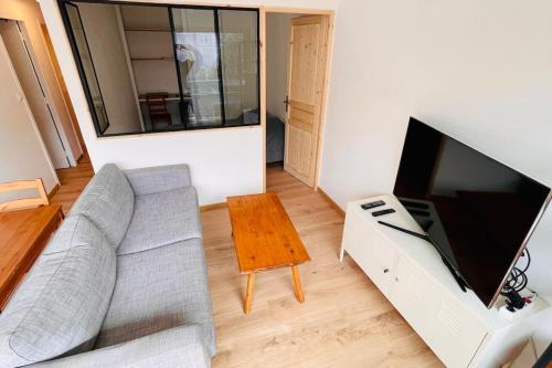 a living room with a couch and a flat screen tv at Furnished Apartment With Balcony & Parking in A Secure Residence in Pessac