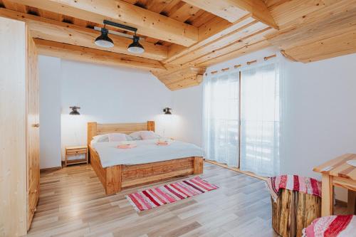 a bedroom with a bed and a wooden ceiling at Penzión Natália in Terchová