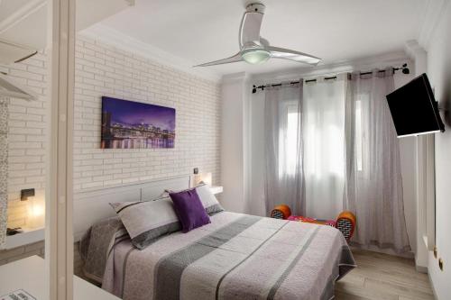 una camera con letto e ventilatore a soffitto di Magara Suite Las Canteras a Las Palmas de Gran Canaria