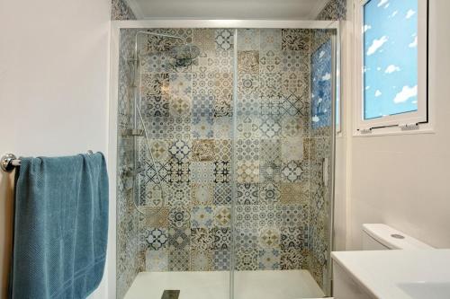 ラスパルマス・デ・グランカナリアにあるMagara Suite Las Canterasのバスルーム(シャワー、青いタオル付)