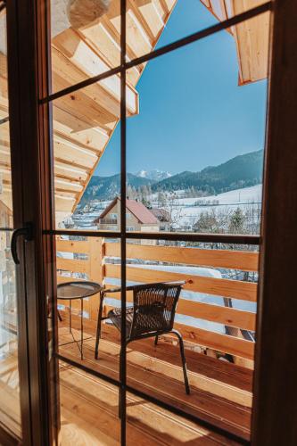 a balcony with a chair and a view of the water at Penzión Natália in Terchová