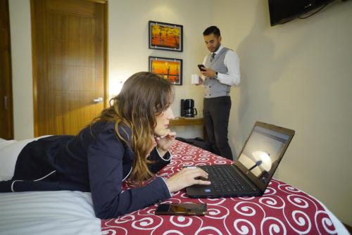 a woman sitting at a table with a laptop computer at Rymma Hotel in Morelia