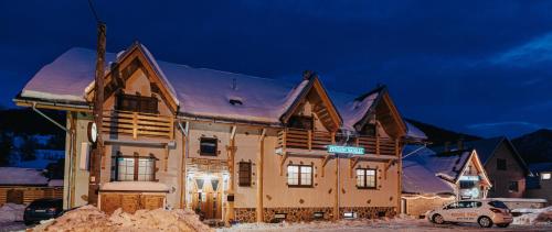 Una casa en la nieve por la noche en Penzión Natália en Terchová