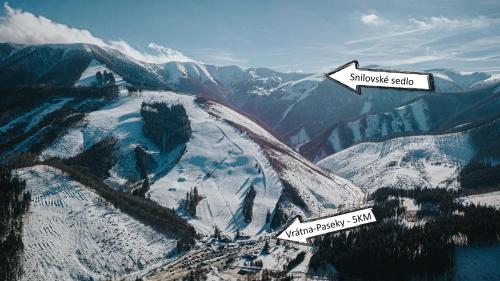 a snow covered mountain with two signs on it at Penzión Natália in Terchová