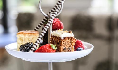 a plate with three pieces of cake and berries at Pendley Manor in Tring