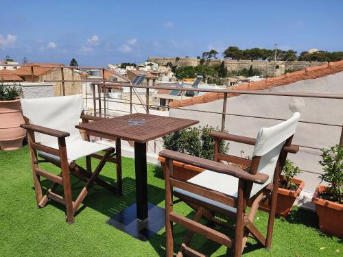 a wooden table and two chairs sitting on a balcony at Archontiko Old Town Suites in Rethymno Town