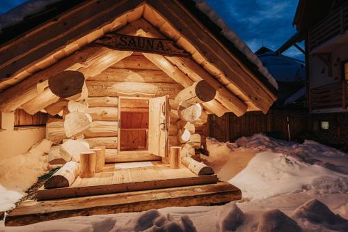 a log cabin with a door in the snow at Penzión Natália in Terchová