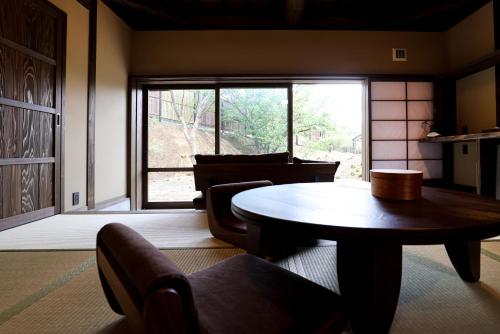 a living room with a table and a large window at kominka neri（古民家煉り） in Miyawaka
