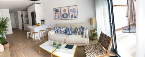 TERRAZAS DEL MAR with POOL في توريمولينوس: غرفة معيشة مع أريكة وطاولة