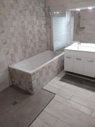 une salle de bain avec une baignoire et un lavabo dans l'établissement Le Soulier En Cévennes 4 étoiles, à Saint-Martin-de-Valgalgues