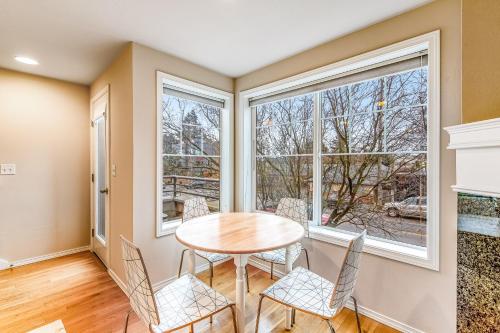 a dining room with a table and chairs and windows at City Sojourn in Seattle