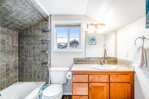 a bathroom with a toilet and a tub and a sink at City Sojourn in Seattle