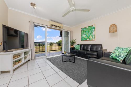 uma sala de estar com um sofá e uma televisão em Charming CBD Apt 3bd 2bth - walk to Waterfront em Darwin