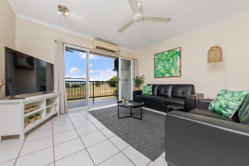 a living room with a couch and a tv at Charming CBD Apt 3bd 2bth - walk to Waterfront in Darwin