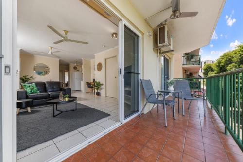 balcón con sofá, mesa y sillas en Charming CBD Apt 3bd 2bth - walk to Waterfront en Darwin
