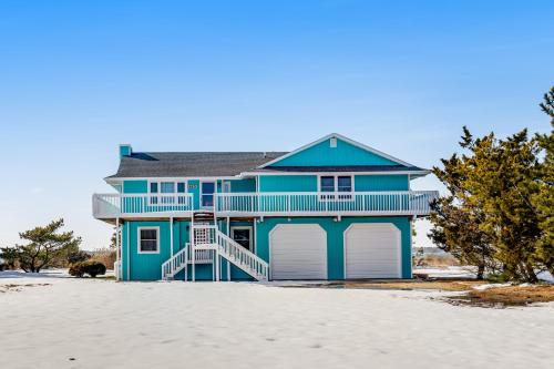 a blue house sitting on the beach with a sandy beach at Fenwick Island --- 1710 Coastal Hwy in Fenwick Island