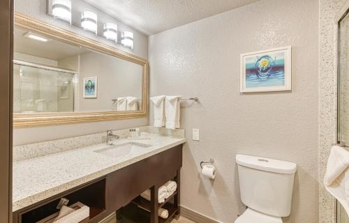 a bathroom with a sink and a toilet and a mirror at Amanzi Hotel, an Ascend Collection Hotel in Ventura