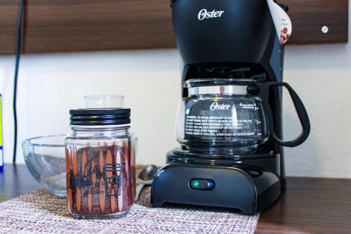 a coffee maker and a glass jar on a table at Rooms in Cancun Airport in Cancún