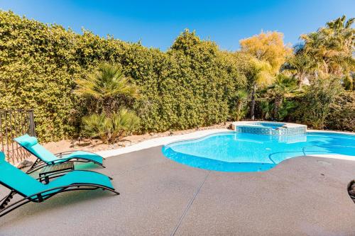 a swimming pool with two lounge chairs next to it at Habanero Hideaway in Oro Valley