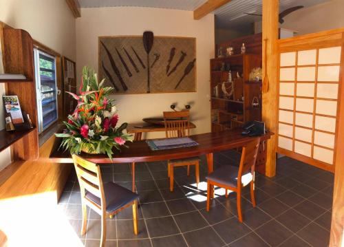 a dining room with a wooden table and chairs at BORA BORA HOLIDAY'S LODGE in Bora Bora