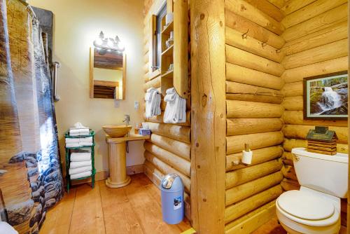 a log cabin bathroom with a toilet and a sink at The Cub Inn in Groveland