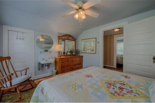 a bedroom with a bed and a chair and a ceiling fan at A Beautiful View & Carriage in Lake Junaluska