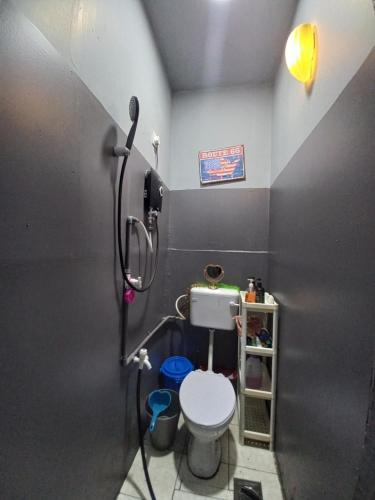 uma pequena casa de banho com WC e chuveiro em Sya Cottage em Kuala Pilah