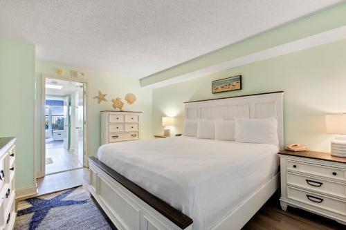 um quarto com uma grande cama branca e um corredor em Boardwalk Beach 131 em Myrtle Beach