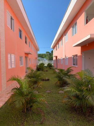 a courtyard of an apartment building with palm trees at Apto novo pertinho da praia em Boracéia, Bertioga in Bertioga