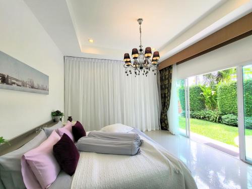 a bedroom with a large bed and a chandelier at Leelawadee Pool Villa BBQ&Pool party in Bang Sare