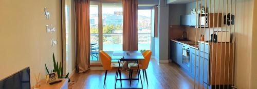 a kitchen with a table and chairs in a room at Eriss Studio Suite - OZone building apartment in Cluj-Napoca
