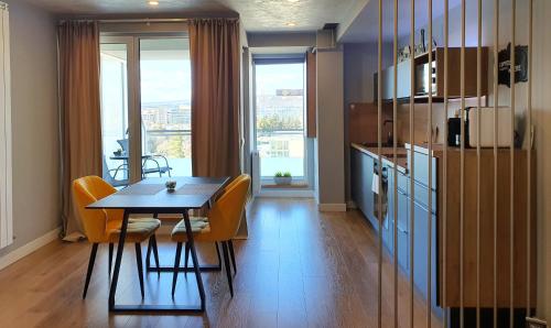 a kitchen with a table and chairs and a refrigerator at Eriss Studio Suite - OZone building apartment in Cluj-Napoca